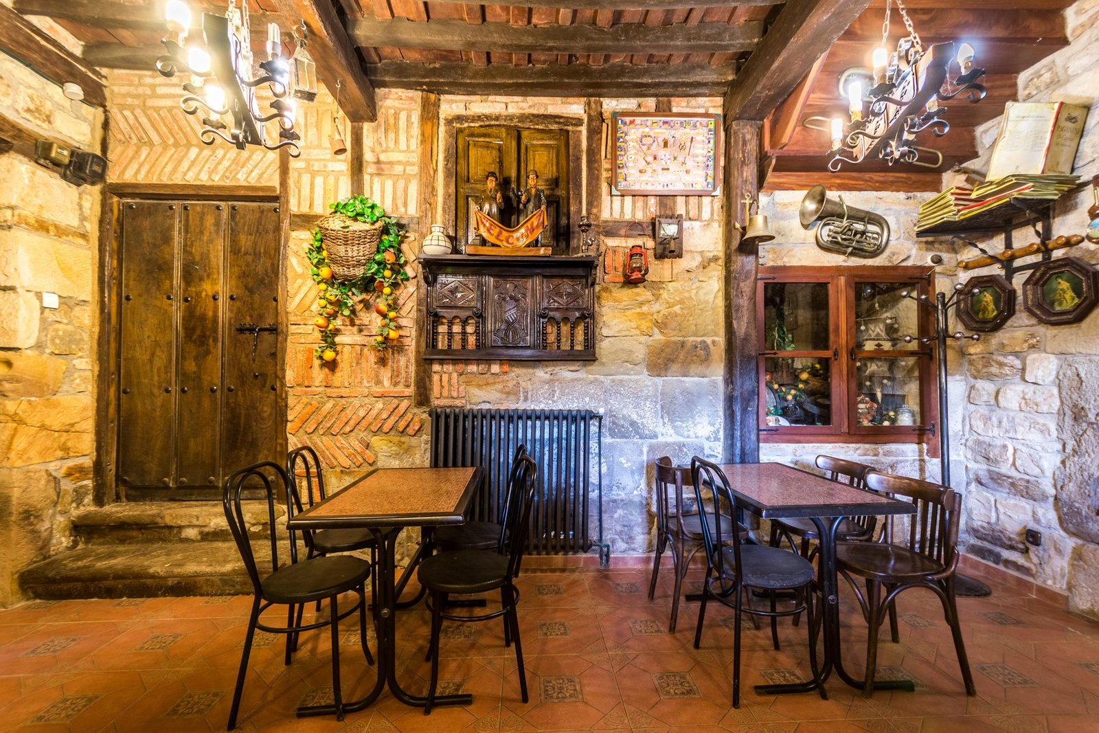 Patio trasero de Finca Gándara con muebles de jardín, hiedra y muros de piedra